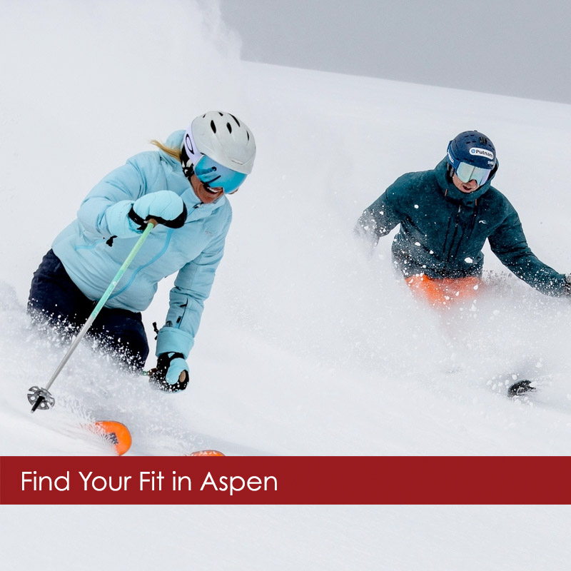 Kjus-skiwear-couple Man and woman in KJUS skiwear skiing powder with Aspen Powder Tours