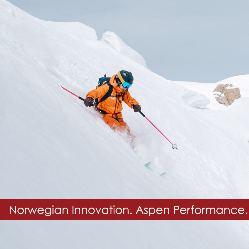 Noronna-ski-jacket-woman Woman wearing a Noronna ski wear outfit skiing on a powder slope