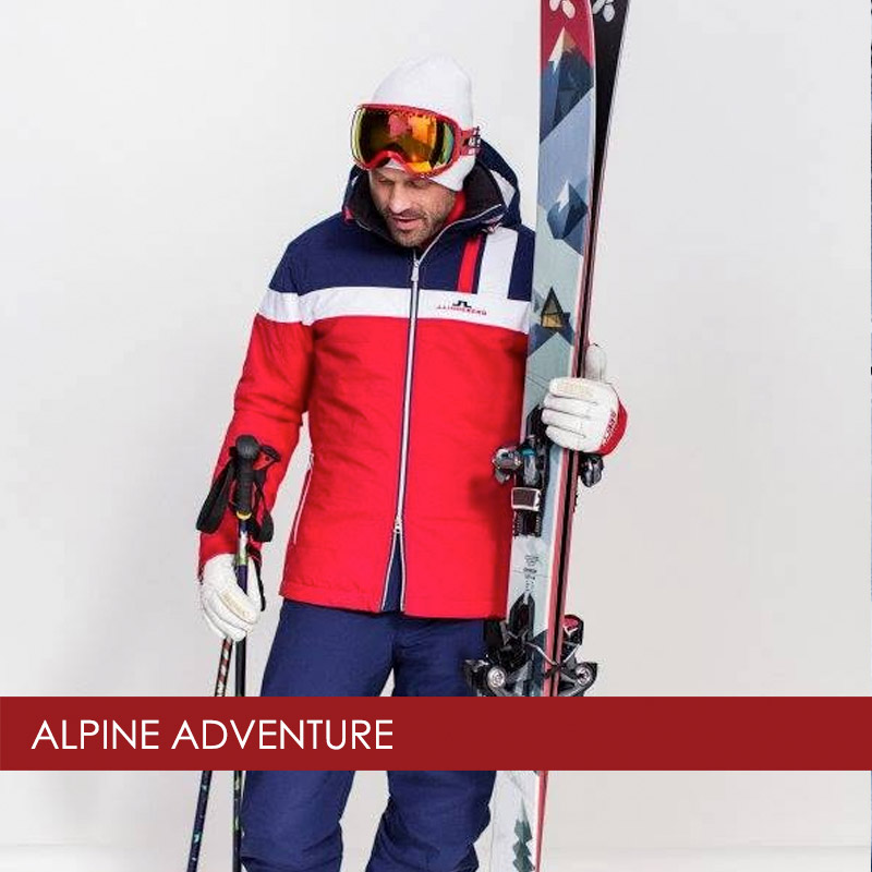 man holding skis wearing J. Lindeberg ski jacket and pants